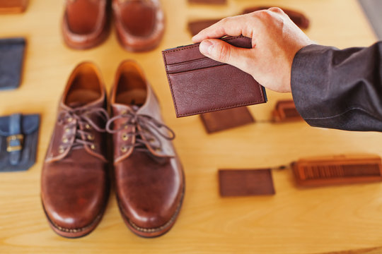 Male hand holding leather card holder nexy yo leather shoes
