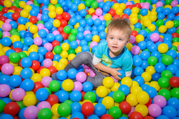 Fototapeta na wymiar kid playing in pool of balls