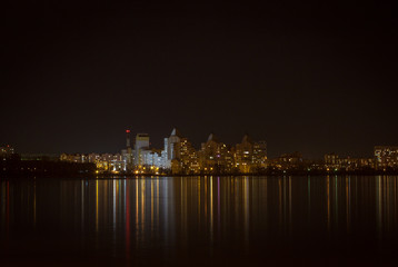 Fototapeta na wymiar Night lights of city buildings reflected in the water. long exposure