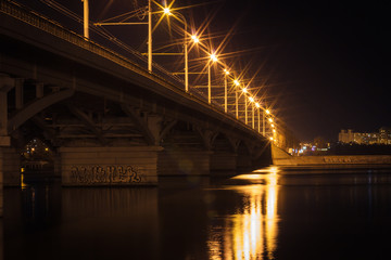 Bridge, city lights reflected in the water. Long exposure