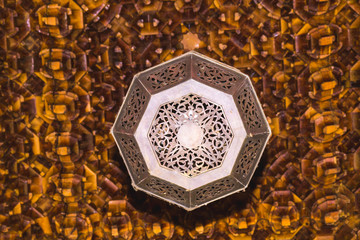 Lamp on a sculptured wooden ceiling