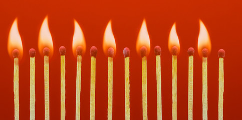 Burning matchsticks setting fire to its neighbors