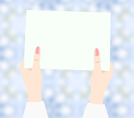 Women's hands holding sheet of white paper. 