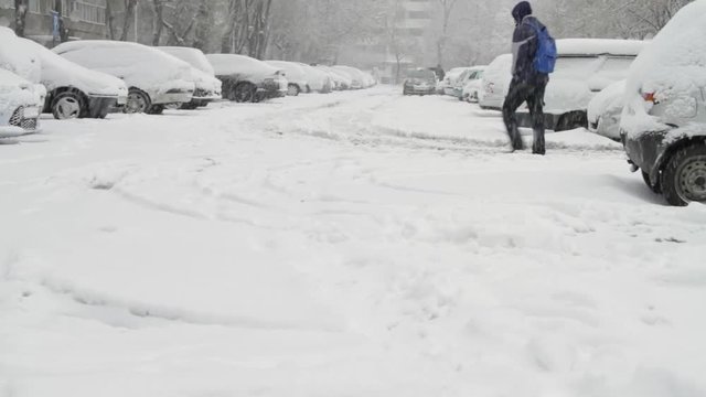 Parking Lot With Cars Covered In Snow, Young Man Talking On The Phone, Blizzard