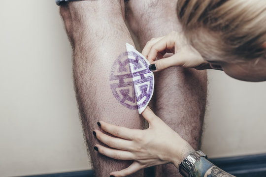 Artist tattoo printing design on human leg