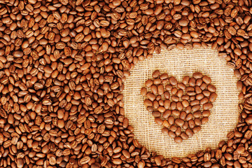 Heart coffee frame made of coffee beans on burlap texture. 
