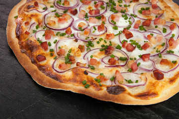 Elsässer Flammkuchen auf Schieferplatte im Anschnitt