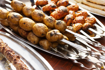Potatoes, mushrooms and meat roasted on skewers