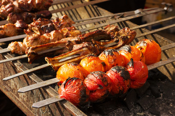 Tomatoes and meat roasted on skewers