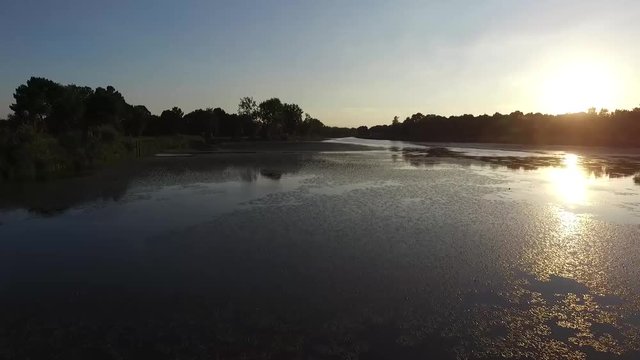 vol drone au dessus d'un lac avec le soleil couchant