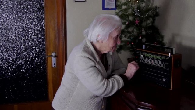99 Years Old Woman Turning The Buttons Of An Old Radio And Listening, Pan