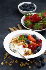 muesli with fresh berries and yogurt for breakfast, vertical