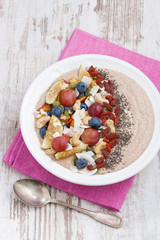 oatmeal with fruit, nuts and chia in white plate