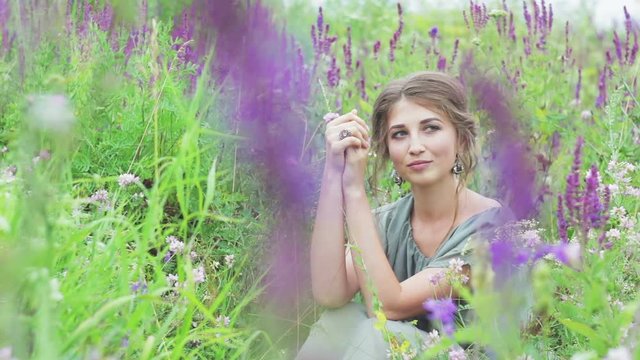 beautiful girl sitting in clover in nature, outdoors