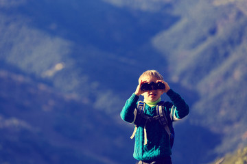 Fototapeta premium little boy with binoculars hiking in mountains