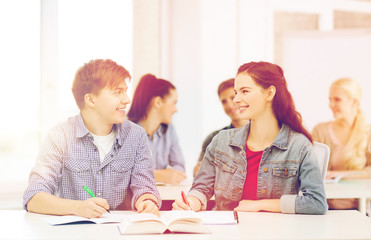Fototapeta premium two teenagers with notebooks and book at school
