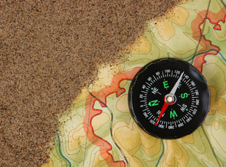 Fototapeta na wymiar compass on the map with sand