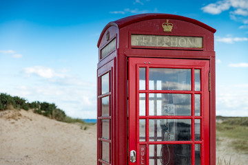 Obraz premium Battered British telephone box on a sandy beach