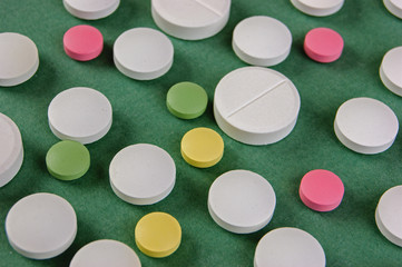 Pills and tablets on a green background