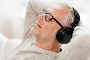 happy man in headphones listening to music at home