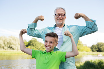 happy grandfather and grandson showing muscles