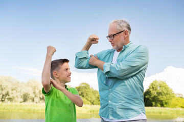 happy grandfather and grandson showing muscles