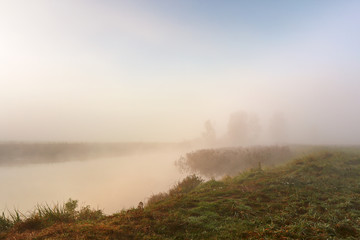 Autumn foggy morning. Dawn on the misty river