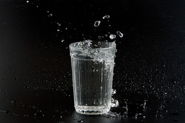 Water is poured into a beaker on a dark background