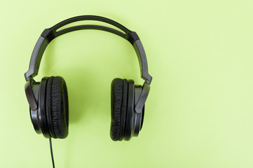 Modern headphones on green background