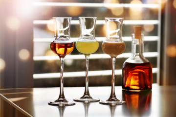Whisky and liqueur in front of a window