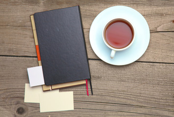 Obraz na płótnie Canvas Blank business cards with pen, notebook and tea cup on wooden office table
