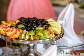 Gourmet buffet table set with fruit and sweets. Grapes, apples, 