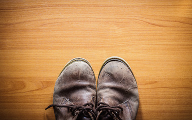 Brown leather shoes on wooden, top view.