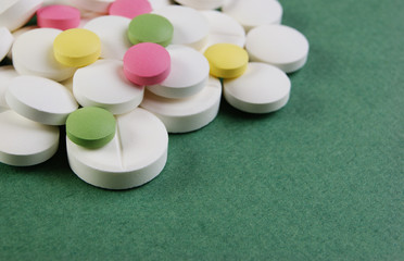 Pills and tablets on a green background