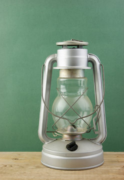 Old kerosene lamp on a wooden table against the wall