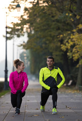 couple warming up before jogging