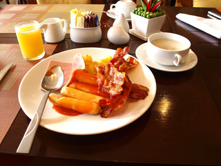 English breakfast with bacon, sausage, baked beans and tea or orange juice