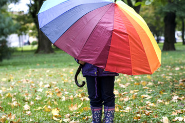 Little girl hiding behind umbrella