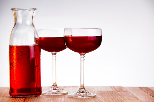 Two glass and carafe of wine on natural wooden table.