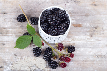 Blackberries on a wooden table and mint leaves