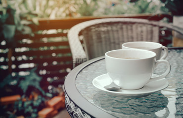 Coffee time in the garden. Coffee White cup on table in the garden