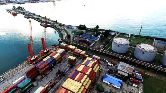 Flying over cargo port in Batumi Georgia 4k aerial video. Shipping containers terminal, water coast, dock cranes, storage