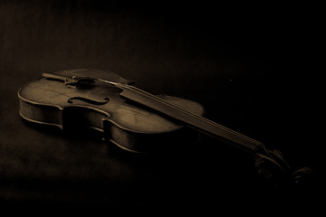 Fototapeta na wymiar Old broken violin on black background