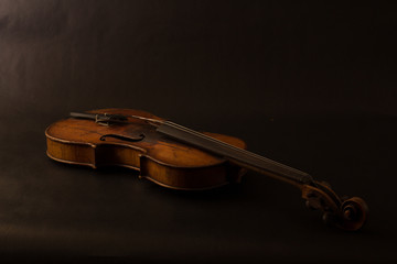 Naklejka na ściany i meble Old broken violin on black background