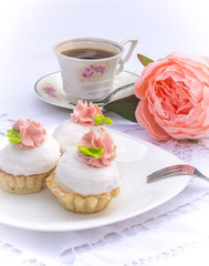 Assorted Fancy Gourmet Cupcakes on a plate. Colorful cupcakes with beautiful decoration over white vintage lace background. Surrounded by flowers and cup of coffee.