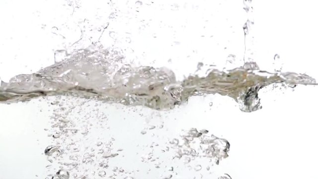 Fruits falling into water on white background slow motion HD video. Water surface with floating whole grape, orange, splash bubbles and waves.