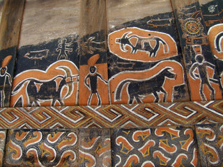 Wood painting of a man and animals on a house wall in Mamasa Valley, Sulawesi