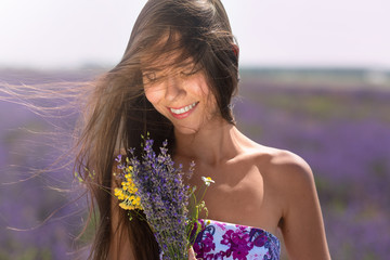 Pretty girl posing on  lavender field, looking fresh and happy