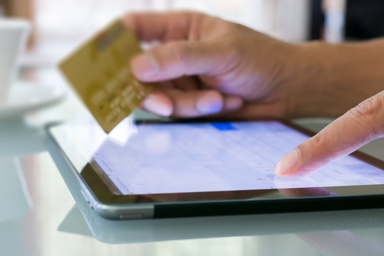 Man using a credit card and tablet for buying on-line