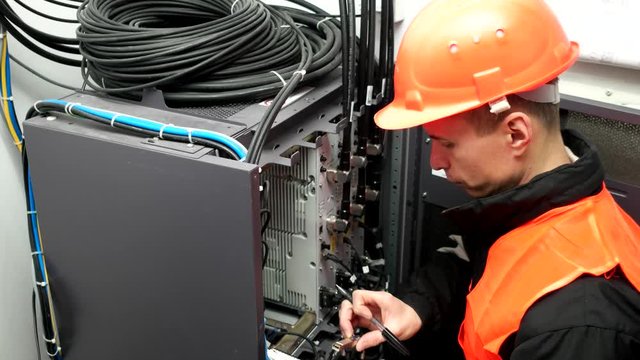 maintenance procedure on server wiring in a data centre. Close Up of network hub and cables. Male engineer of carries out an inspection server. Switch Lever On A Control Panel Of Industrial Machine